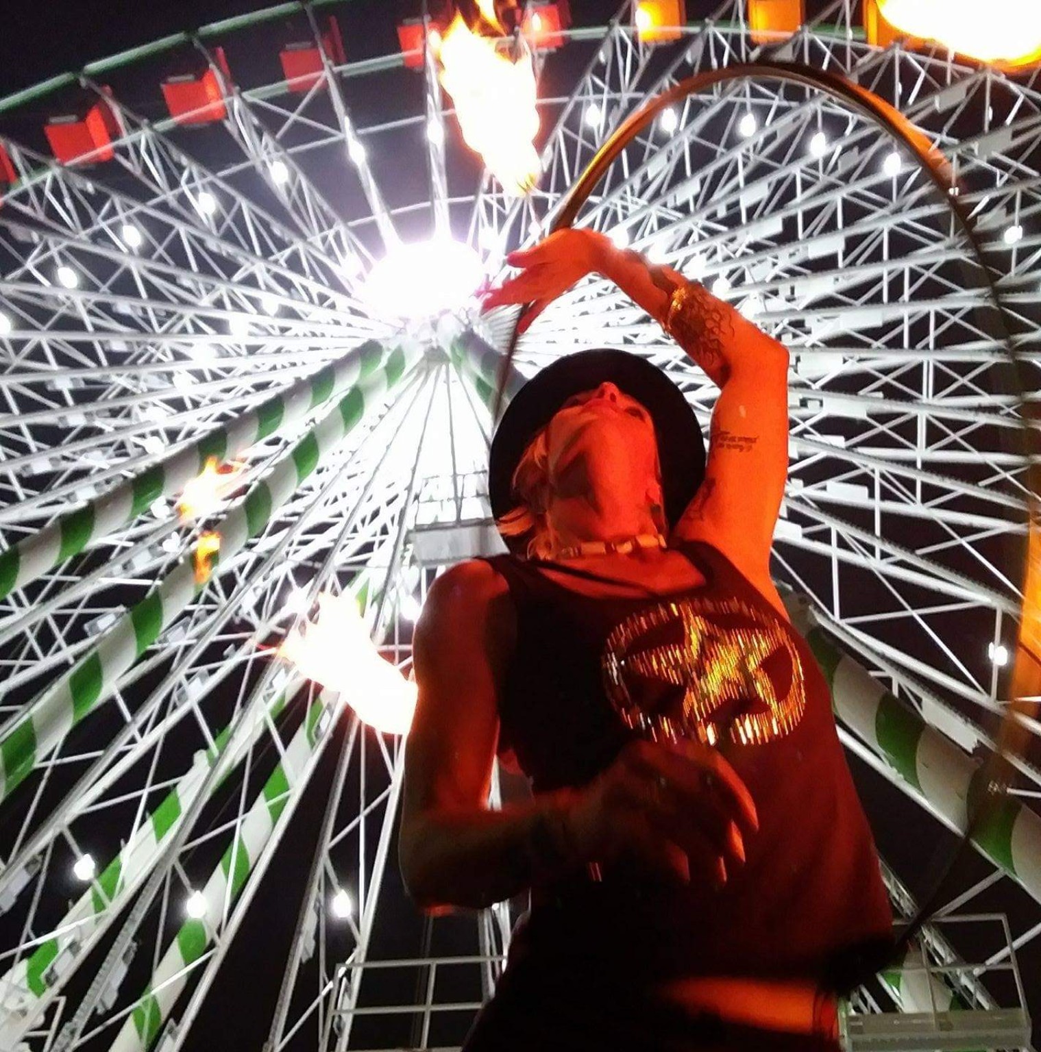 Brandy performing with fire in front of a Carnival Ferris wheel